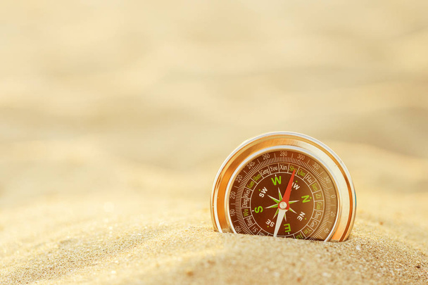 Магнітний срібний компас на піску
 - Фото, зображення