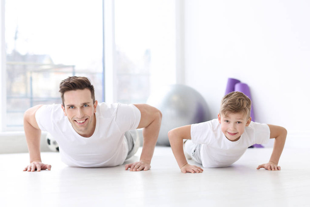 Dad and his son training in gym - 写真・画像