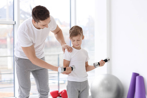 Dad and his son training with dumbbells in gym - Foto, immagini
