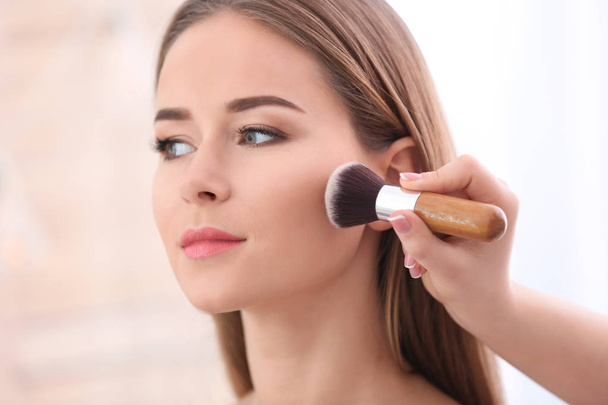 Artista de visagem profissional aplicando maquiagem no rosto da mulher no salão, close-up
 - Foto, Imagem