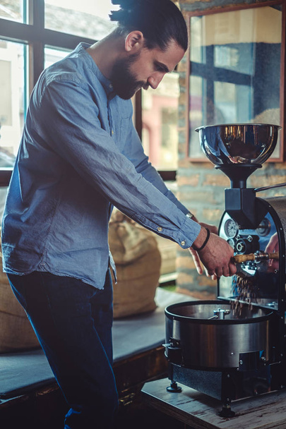 Człowiek nalewania ziarna kawy, które on palona - Zdjęcie, obraz