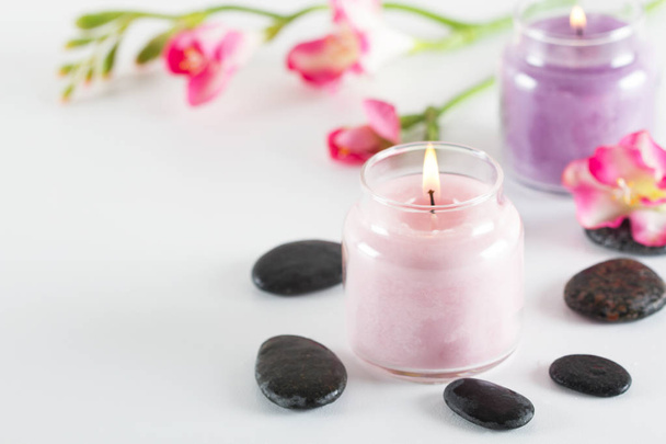 Candles, stones and flowers on white table - Foto, imagen