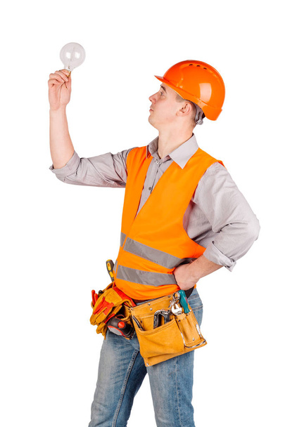 portrait of a male builder in a helmet over white wall background. repair, construction, building, people and maintenance concept. - Foto, immagini