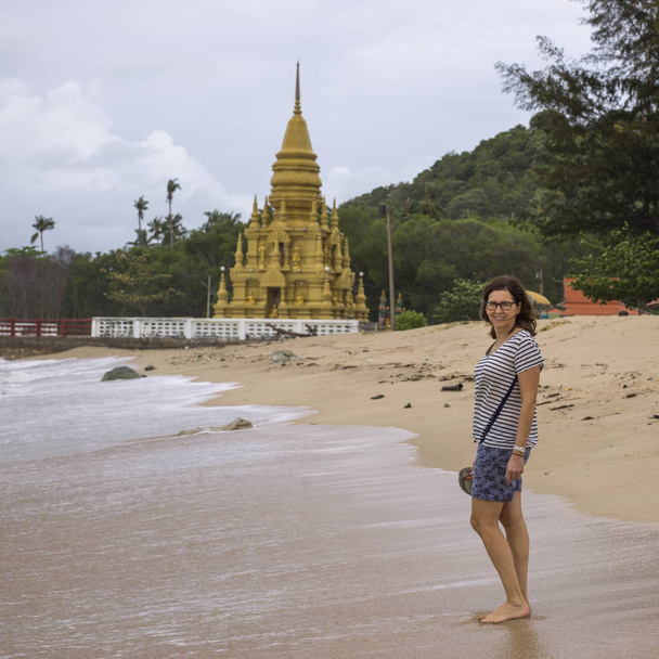 Arka planda, Koh Samui, Surat Thani Eyaleti, Tayland Laem Sor Pagoda ile sahilde duran kadın turist - Fotoğraf, Görsel