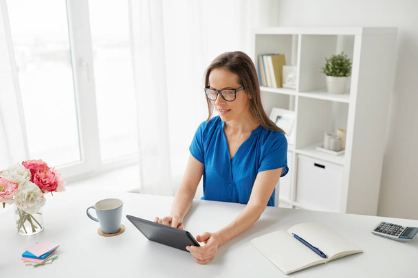 woman with tablet pc and coffee at home or office - Photo, Image