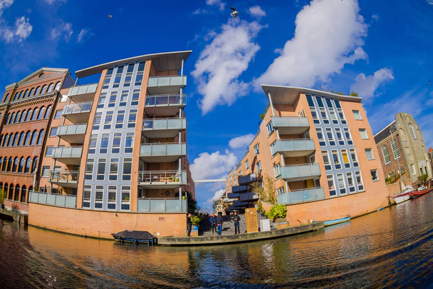 AMSTERDAM, NETHERLANDS, MARCH, 10 2018: Outdoor view of apartment buildings on a canal in the city of Amsterdam - Foto, Imagen