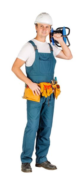male builder or manual worker in helmet over white wall background. repair, construction, building, people and maintenance concept - Foto, Imagen