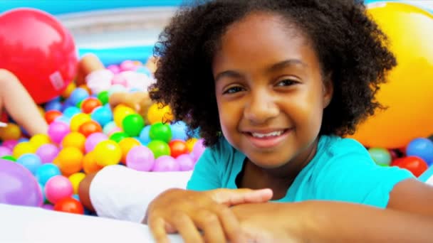 Multiethnische Kinder spielen Ball gefülltes Becken - Filmmaterial, Video