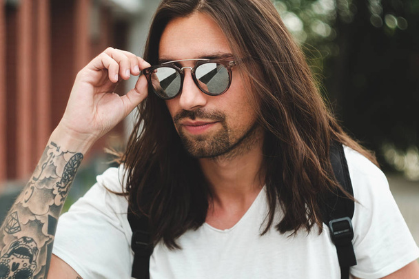 Portrait attractive man with sunglasses on urban background smil - 写真・画像