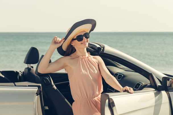 Young woman drive a car on the beach - Фото, изображение