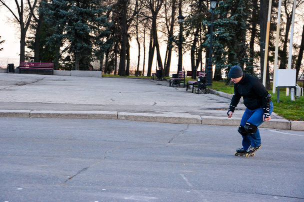 Роликова активність людини катається на ковзанах в центрі міста на заході сонця. Зима. Вуличне катання на роликах
. - Фото, зображення