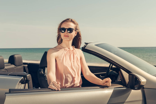 若い女性はビーチに車を運転します。 - 写真・画像