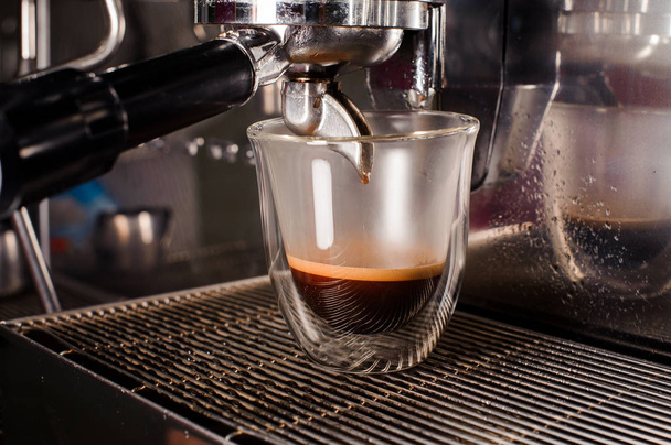 Кофеварка наливает свежий и ароматный кофе в чашку
 - Фото, изображение