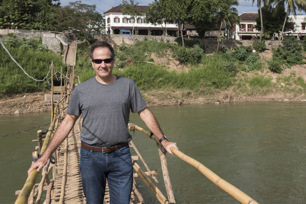 竹橋の上に立つ男,ナムカーン川,ルアンパバーン,ラオス - 写真・画像