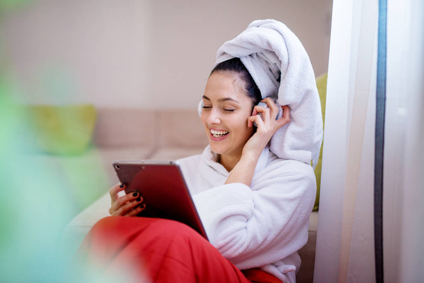 Gelukkige vrouw, luisteren naar muziek op hoofdtelefoon met behulp van Tablet PC  - Foto, afbeelding
