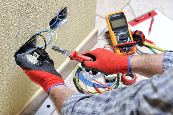Electrician technician at work with safety equipment on a residential electrical system - Photo, Image