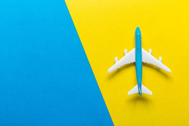 Closeup of miniature airplane on colored background. Travel or vacation concept - Zdjęcie, obraz