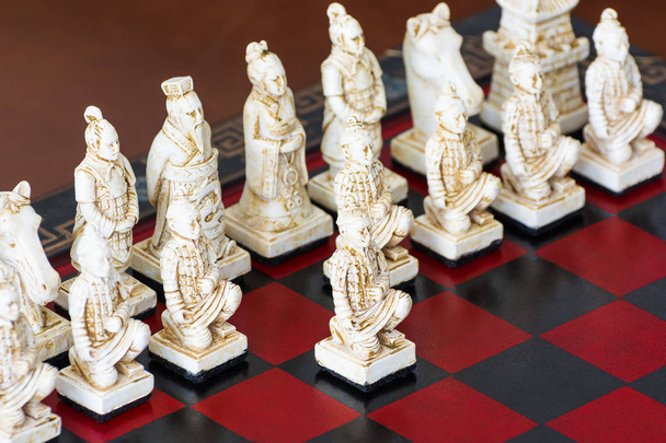 Різьблені шахові фігури в китайському стилі на шахівниці
. - Фото, зображення