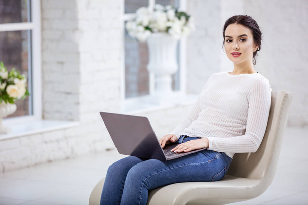 Beautiful young woman using laptop  - Фото, изображение