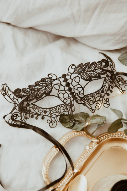 stylish gold tray and black mask on soft bed. flat lay woman essentials for a holiday. instagram photo - Foto, Imagem