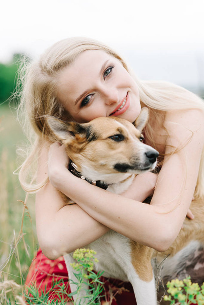 young girl on nature on a green background with a dog - Foto, afbeelding