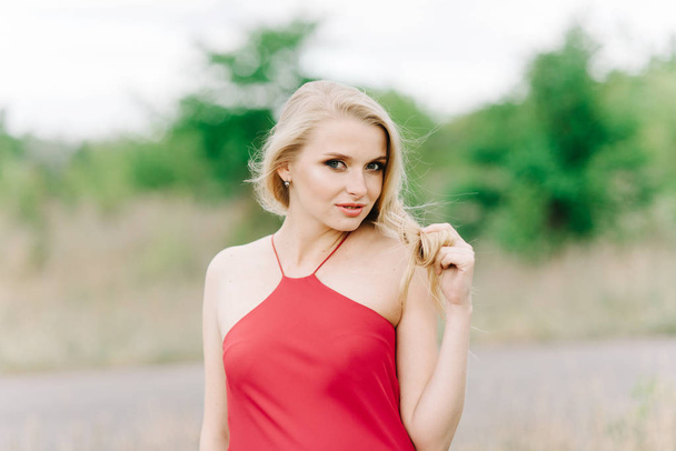 young girl with white hair on a green background in a red dress - Foto, Imagem