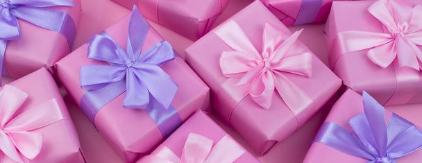 Banner dekorative Weihnachtsgeschenkboxen mit rosa Farbe auf rosa Hintergrund. flache Ansicht von oben - Foto, Bild