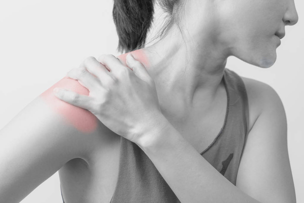 Closeup vrouwen nek en schouder pijn/letsel met rode hoogtepunten op het gebied van de pijn met een witte achtergrond, gezondheidszorg en medische concept - B&W filter - Foto, afbeelding