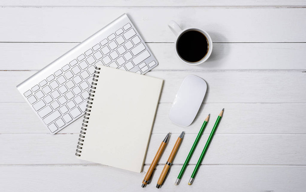 Mesa de escritorio de oficina blanca de madera con taza de café, cuaderno, pluma
 - Foto, imagen