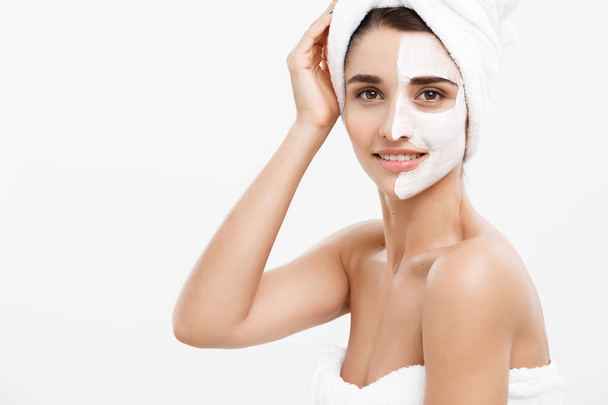 Beauty Skin Care Concept - Beautiful Caucasian Woman Face Portrait applying cream mask on her facial skin white background. - Fotó, kép