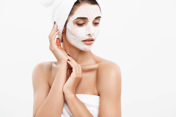 Beauté Skin Care Concept - Belle femme caucasienne visage Portrait appliquer masque crème sur son visage peau fond blanc
. - Photo, image