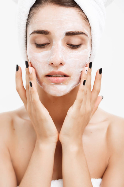 Концепція догляду за шкірою красива кавказька жінка обличчя Портрет нанесення кремової маски на шкіру обличчя білий фон
. - Фото, зображення