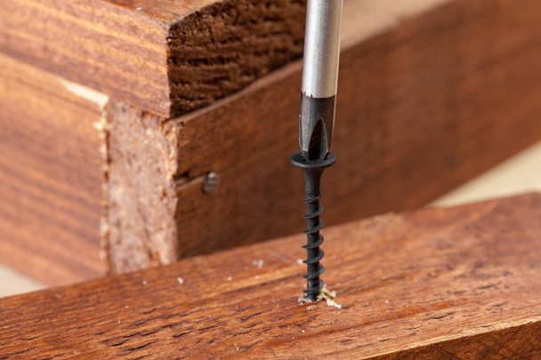 screw screwed into wooden bar - 写真・画像