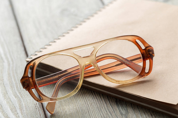 notepad and old fashioned eyeglasses on table - Foto, Bild