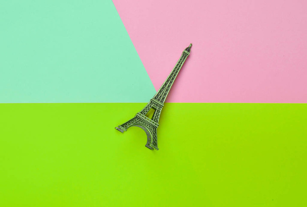 Souvenir beeldje van de Eiffeltoren op een veelkleurige achtergrond van pastel. Trend van minimalisme. - Foto, afbeelding