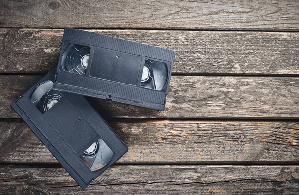 Duas cassetes de vídeo de plástico dos anos 80 numa mesa de madeira rústica. Vista superior
. - Foto, Imagem