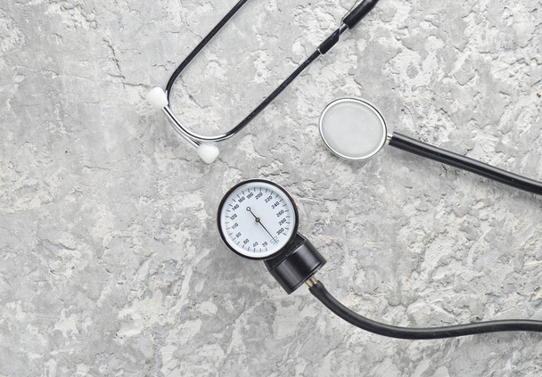 Cardiological medical equipment for measuring pressure on a concrete surface. Stethoscope and measure meter. Top view. - Photo, Image