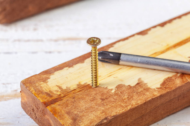 screw screwed into wooden bar - 写真・画像