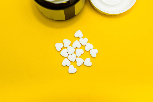 Tablets in the form of heart on a yellow background - Photo, Image
