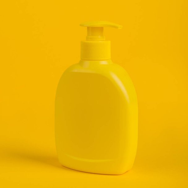 Cosmetic bottle isolated on yellow background. - Fotoğraf, Görsel