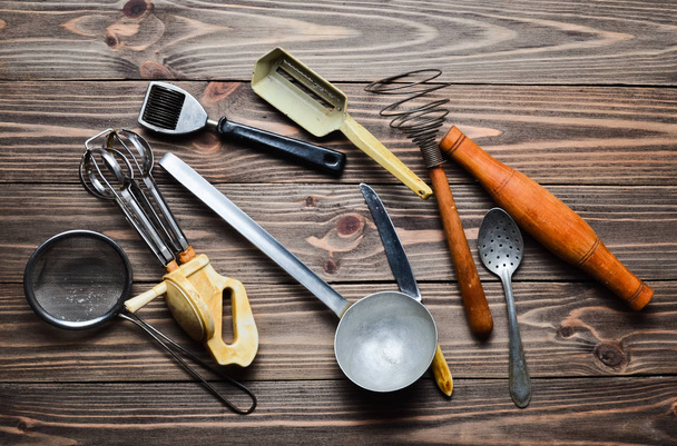 Набір старих кухонних інструментів і столових приборів на дерев'яному столі. Вінтажне приготування їжі на кухні. Вид зверху
. - Фото, зображення