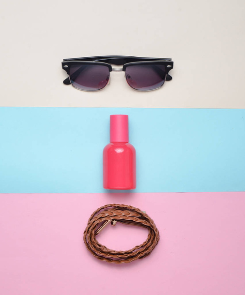 Women's trendy accessories on a multicolored pastel background. Glasses, perfume, leather belt. Top view. Minimalism. - Photo, Image