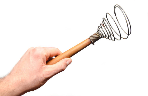Ένας άνθρωπος του χέρι κρατά ένα σύρμα που απομονώνονται σε λευκό φόντο. Εργαλεία κουζίνας για μαγείρεμα. - Φωτογραφία, εικόνα