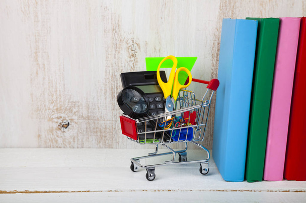 Items for school in a shopping trolley and books - Foto, Imagem