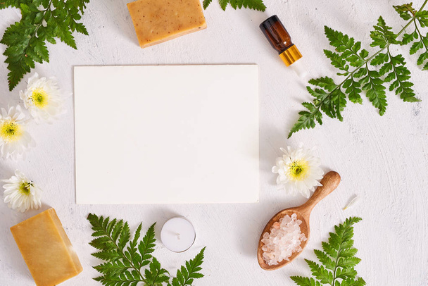 Badezimmersalz, Seife und Aromaöl für den Wellnessbereich auf weißem Hintergrund von oben - Foto, Bild