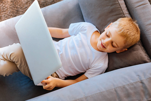 Pleasant delighted boy resting on the sofa - Foto, imagen