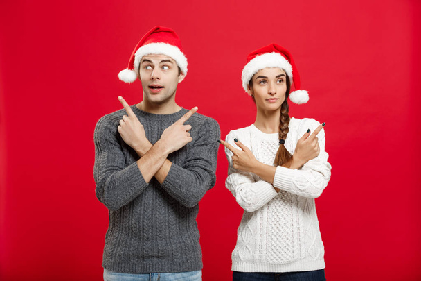 Weihnachtskonzept - Porträt schönes junges Paar Finger auf Seite  - Foto, Bild