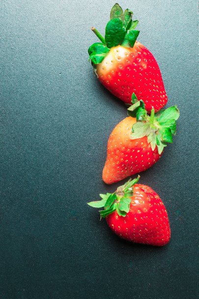 Fresh organic red strawberry on dark green background - Photo, Image