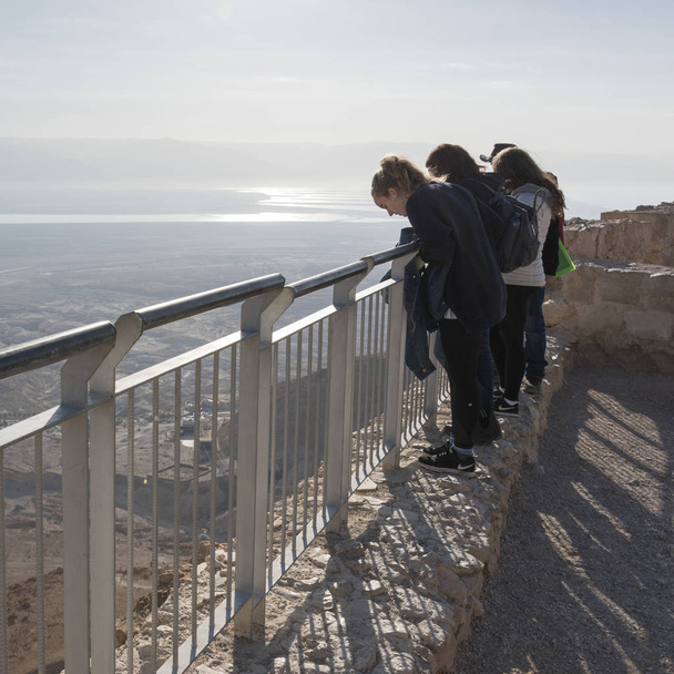 Turistas em pé no terraço do forte, Masada, Deserto da Judeia, Região do Mar Morto, Israel
 - Foto, Imagem