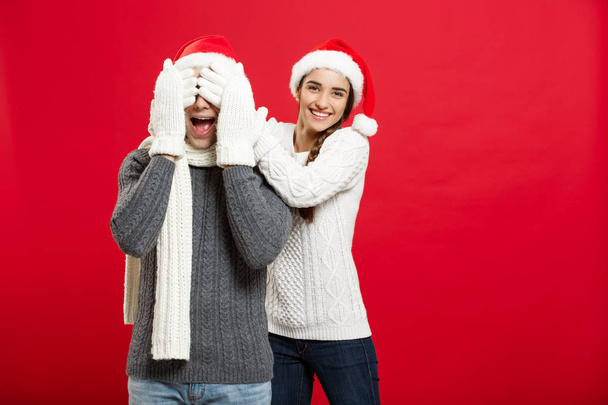 Christmas Concept - portrait lovely girlfriend surprising close her boyfriend eyes in Christmas day - Foto, Imagem